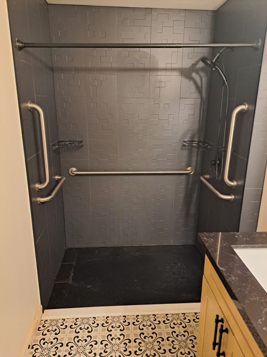 Roll-in style shower with grab bars and a handheld showerhead at Fountain of Blessings
